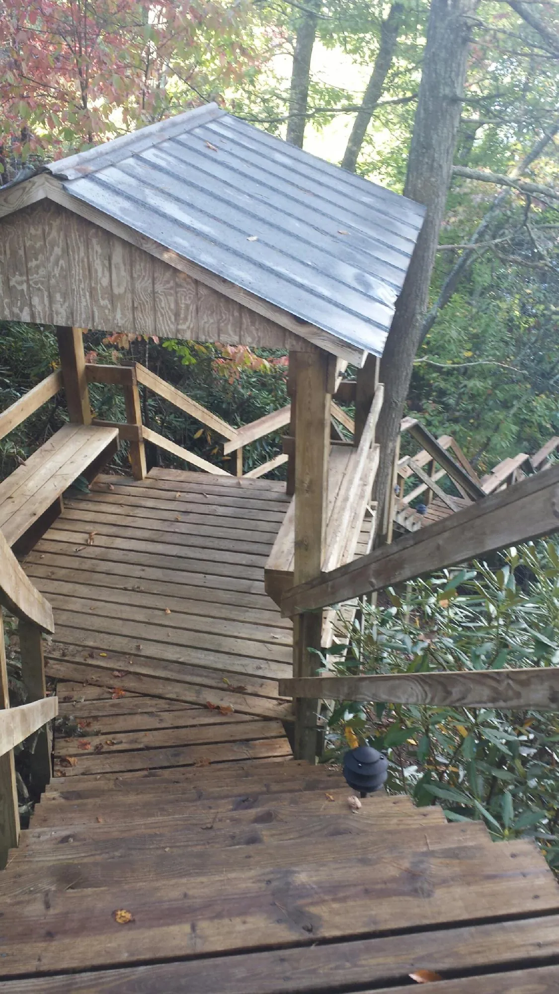 Metal roofed shelter over wooden steps on a wooded walkway — Skylight Repair & Installation work by our crew in Waimanalo